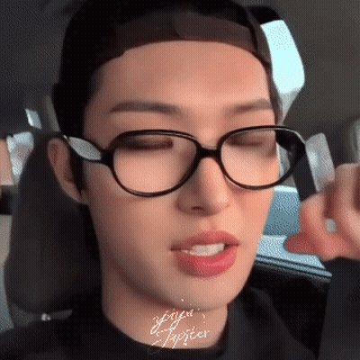 A Close Up Of A Person Wearing Glasses And A Black Shirt GIF