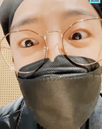 A Close Up Of A Person Wearing Glasses And A Mask That Says Vlive On The Bottom GIF