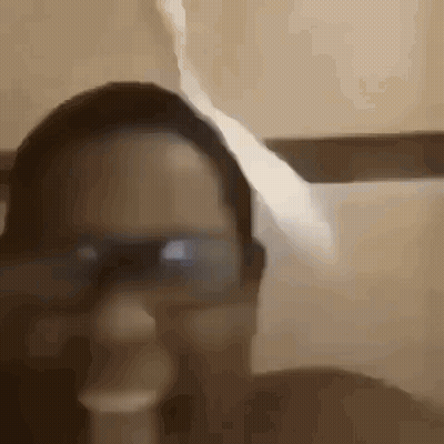 A Close Up Of A Person Wearing Glasses And Smoking A Cigarette In A Bathroom . GIF