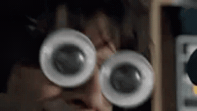 A Close Up Of A Person Wearing Glasses With Big Eyes . GIF
