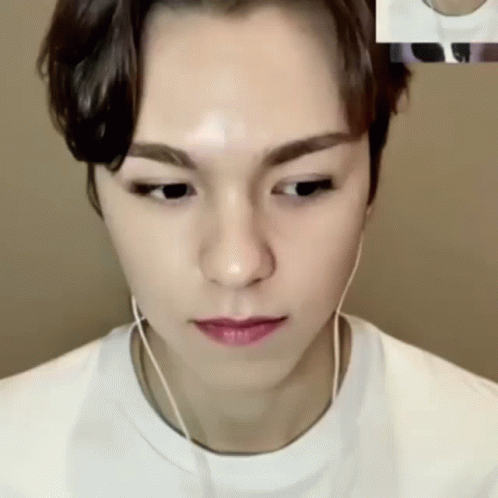 A Close Up Of A Person Wearing Headphones And A White Shirt GIF