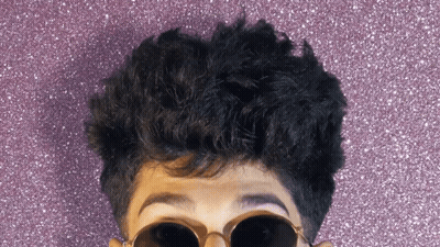 A Close Up Of A Person Wearing Sunglasses And A Purple Background GIF