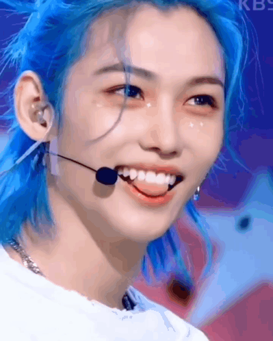 A Close Up Of A Person With Blue Hair And A Microphone . GIF