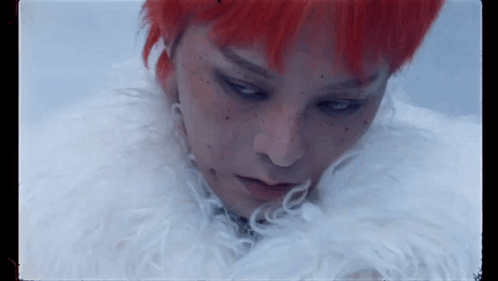 A Close Up Of A Person With Red Hair And Freckles Wearing A White Fur Coat . GIF