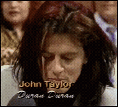 A Close Up Of A Person With The Name John Taylor Written On The Bottom GIF
