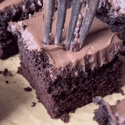 A Close Up Of A Piece Of Chocolate Cake With A Fork Sticking Out Of It GIF