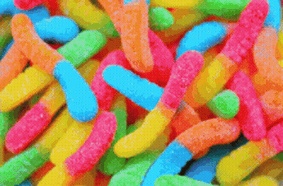 A Close Up Of A Pile Of Colorful Gummy Worms GIF