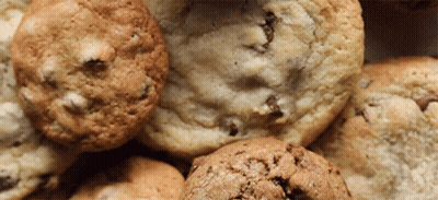 A Close Up Of A Pile Of Cookies Including Chocolate Chip Cookies GIF
