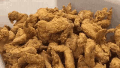 A Close Up Of A Pile Of Fried Chicken GIF
