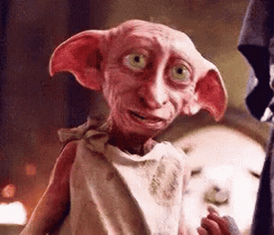 A Close Up Of A Pink Dobby From Harry Potter Standing Next To A Person . GIF