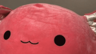 A Close Up Of A Pink Stuffed Animal With A Black Circle In The Middle GIF
