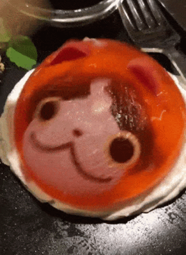 A Close Up Of A Plate Of Food With A Cat Face Drawn On It GIF