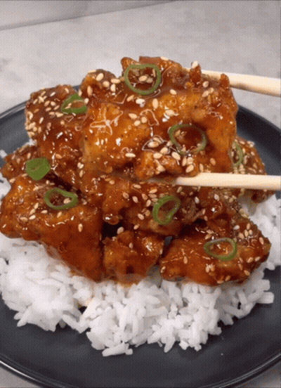 A Close Up Of A Plate Of Food With Rice And Chopsticks GIF