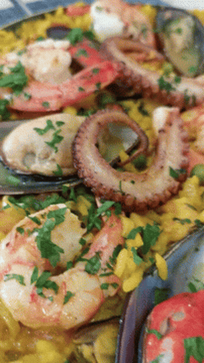A Close Up Of A Plate Of Food With Shrimp Octopus Mussels And Rice GIF