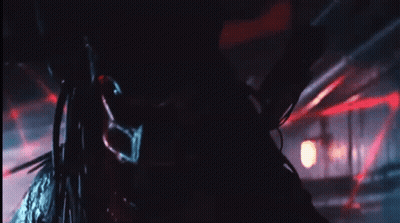 A Close Up Of A Predator In A Dark Room With Red Lights GIF