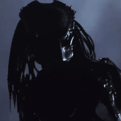 A Close Up Of A Predator 'S Face With A Blurred Background GIF