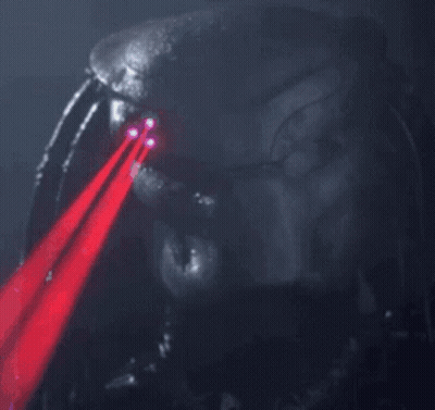 A Close Up Of A Predator 'S Face With Red Lasers Coming Out Of His Eyes GIF