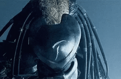 A Close Up Of A Predator 'S Head With Dreadlocks And A Helmet . GIF