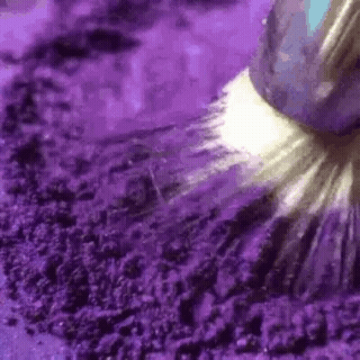 A Close Up Of A Purple Powder With A Brush . GIF