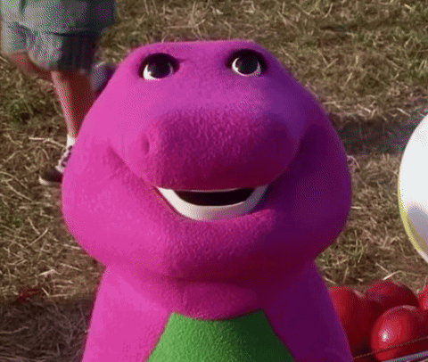 A Close Up Of A Purple Stuffed Animal With A Green Triangle On His Chest . GIF