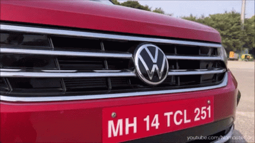 A Close Up Of A Red Volkswagen With A License Plate That Says Mh 14 Tcl 251 GIF