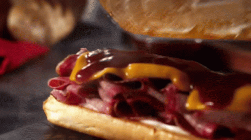 A Close Up Of A Roast Beef Sandwich With Cheese GIF