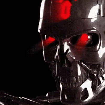 A Close Up Of A Robot Skull With Red Lights On Its Eyes GIF