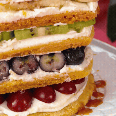 A Close Up Of A Sandwich With Blueberries And Cherries On A Plate GIF