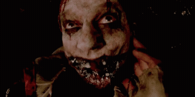 A Close Up Of A Scary Clown 'S Face With Blood Coming Out Of His Mouth . GIF