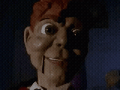 A Close Up Of A Scary Puppet With A Shadow On His Face . GIF