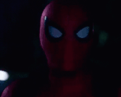 A Close Up Of A Spider-Man 'S Face With A Flashlight In The Background . GIF
