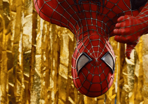 A Close Up Of A Spider Man 'S Face With A Gold Background GIF