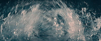A Close Up Of A Splash Of Water In A Dark Room GIF