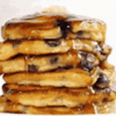 A Close Up Of A Stack Of Pancakes With Syrup On Top . GIF