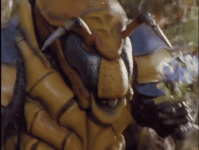 A Close Up Of A Statue Of A Bug With Horns And Sharp Teeth GIF