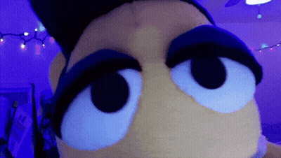 A Close Up Of A Stuffed Animal 'S Eyes In A Purple Room GIF