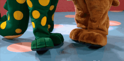 A Close Up Of A Stuffed Animal 'S Feet With A Polka Dot Costume On GIF