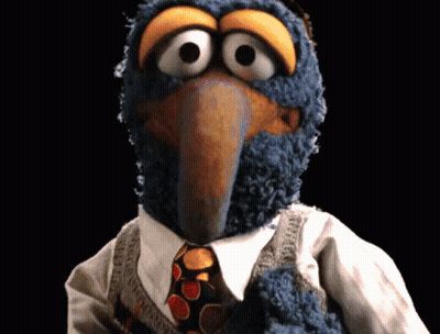 A Close Up Of A Stuffed Animal Wearing A Tie GIF
