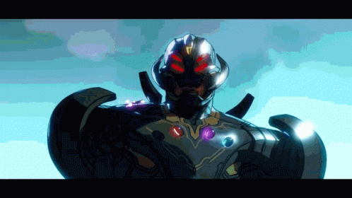 A Close Up Of A Superhero With Red Eyes And Purple Gems On His Chest GIF