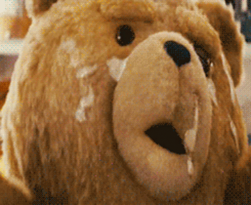 A Close Up Of A Teddy Bear 'S Face With Milk Dripping Out Of It 'S Mouth GIF