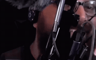 A Close Up Of A Toilet In A Dark Room With A Person Standing Next To It . GIF