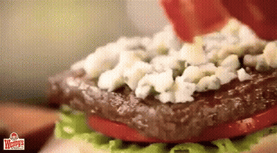 A Close Up Of A Wendy 'S Burger With Lettuce Tomatoes And Blue Cheese GIF
