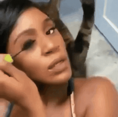 A Close Up Of A Woman Applying Mascara To Her Eye GIF