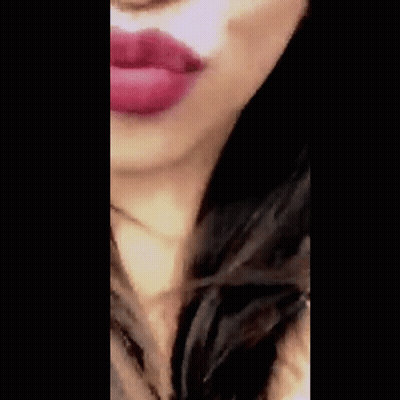 A Close Up Of A Woman Blowing A Kiss With Red Lipstick . GIF