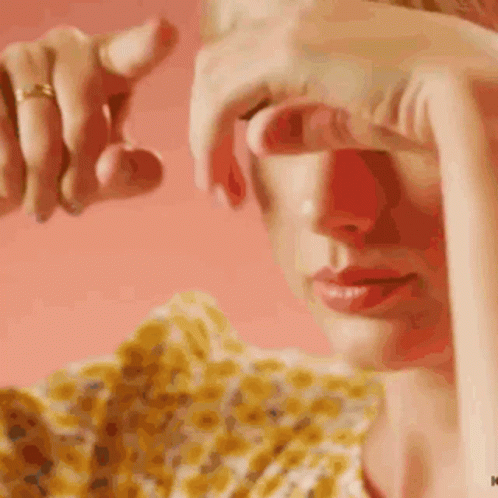 A Close Up Of A Woman Covering Her Eyes With Her Hands GIF