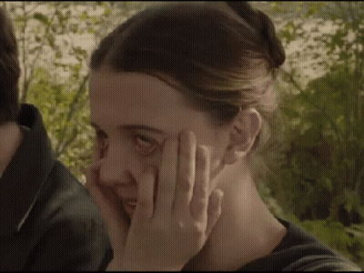 A Close Up Of A Woman Covering Her Face With Her Hand . GIF