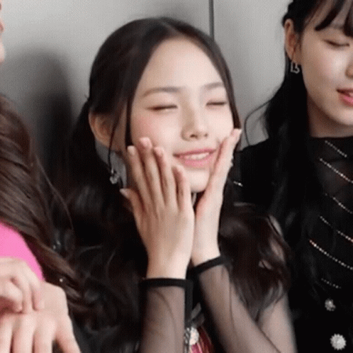 A Close Up Of A Woman Covering Her Face With Her Hands . GIF