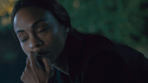 A Close Up Of A Woman Covering Her Mouth With Her Hands GIF