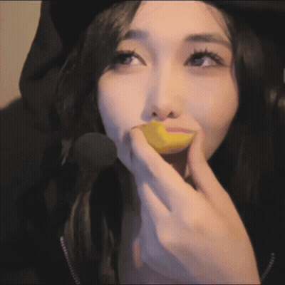 A Close Up Of A Woman Eating A Yellow Object GIF