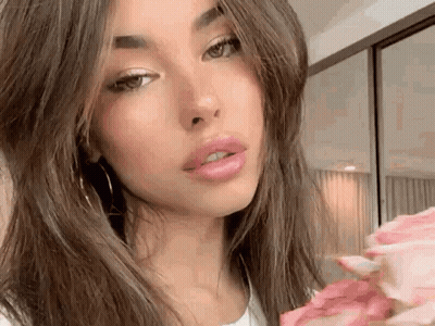 A Close Up Of A Woman Holding A Bouquet Of Flowers . GIF